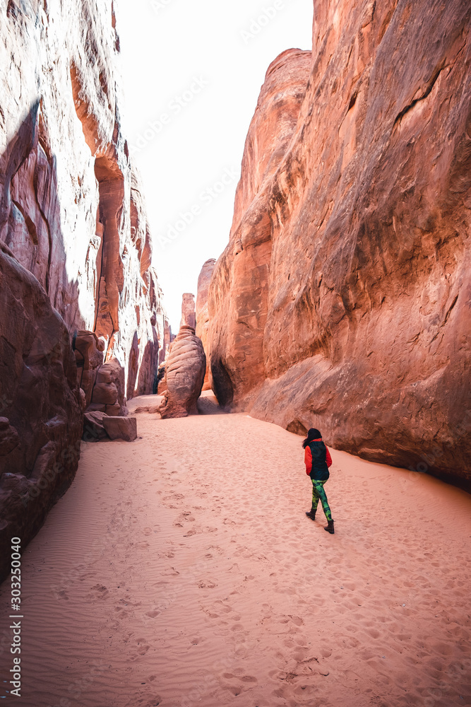 Woman hiking through desert canyon