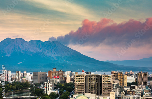 Kagoshima, Japan, October 2019 - Cityscape with Mount Sakurajima constant smoking background, shot during sunset blue hour.