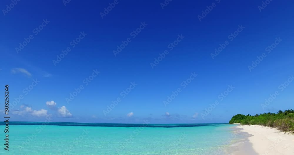 Clear blue sky of morning lightening calm and clear turquoise lagoon, washing quiet beach of tropical island with lush vegetation in Barbados Clear blue sky of morning lightening calm and clear turquoise lagoon, washing quiet beach of tropical island with lush vegetation in Barbados
