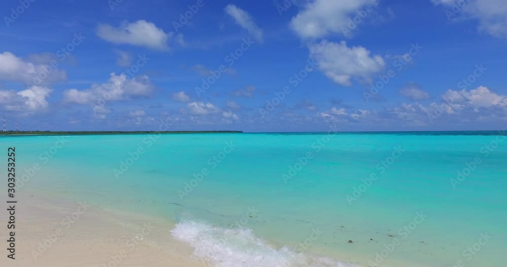 Static clouds on bright blue sky hanging over wide turquoise lagoon with calm clear water washing exotic beach in Bora bora Static clouds on bright blue sky hanging over wide turquoise lagoon with calm clear water washing exotic beach in Bora bora