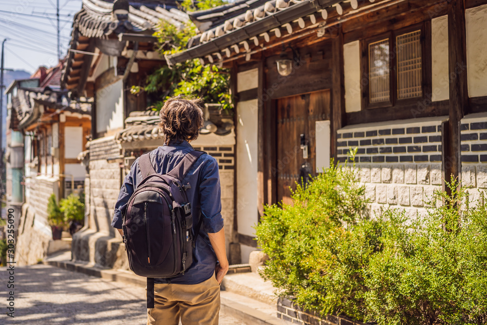 Young man tourist in Bukchon Hanok Village is one of the famous place for Korean traditional houses have been preserved. Travel to Korea Concept