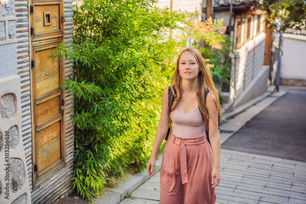 Young woman tourist in Bukchon Hanok Village is one of the famous place for Korean traditional houses have been preserved. Travel to Korea Concept Young woman tourist in Bukchon Hanok Village is one of the famous place for Korean traditional houses have been preserved. Travel to Korea Concept