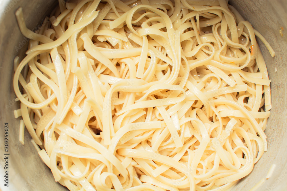 Yellow spaghetti after cooking in an enamel saucepan.