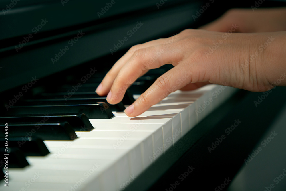 Fototapeta premium Closeup female hands playing piano