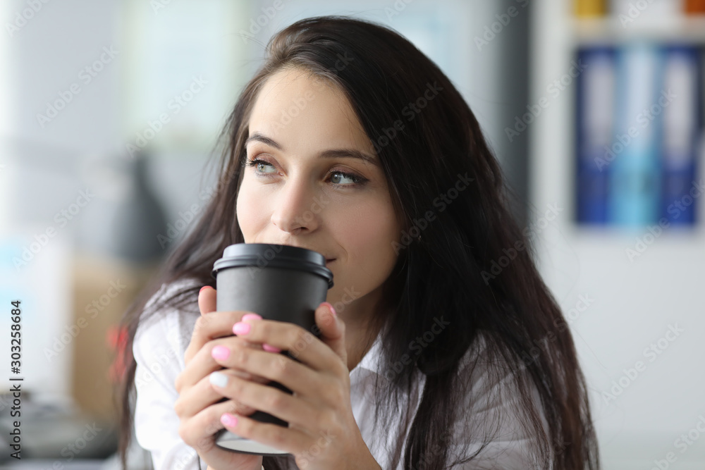 Woman drinking tea in office Woman drinking tea in office