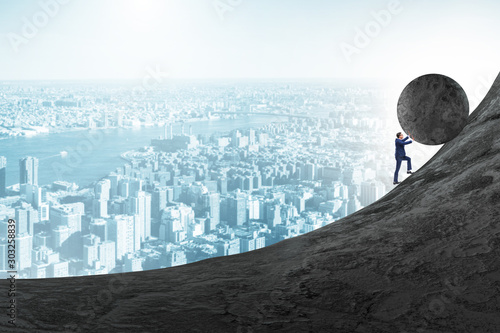 Foto Man pushing large stone to the top