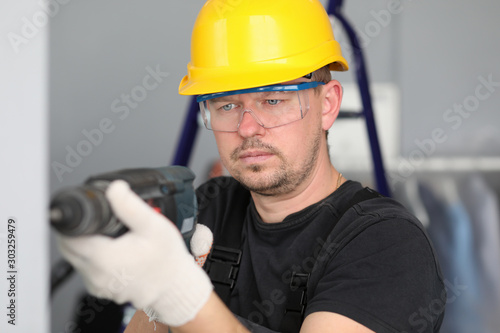 Worker with drill in room