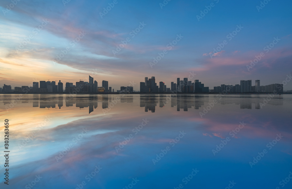 City Skyline By River Against Sky at twilight.