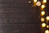 Christmas golden lights on dark wooden background