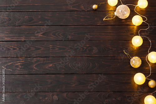 Christmas golden lights on dark wooden background