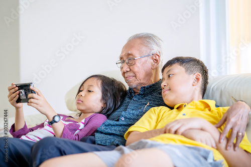 grandfather and grandchildren watching a movie