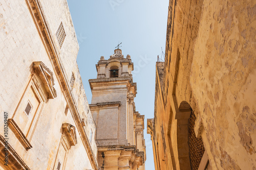 Narrow Maltese streets in the town of Mdina, view of the church bell tower. photo