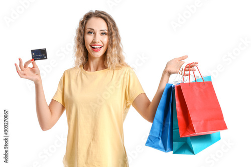 Young woman with credit card and shopping bags on white background
