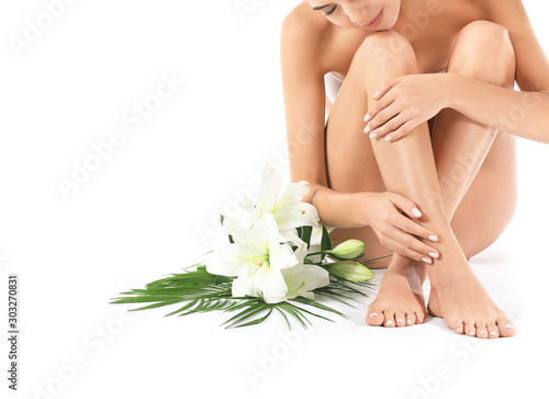 Beautiful young woman with flowers isolated on white. Spa treatment