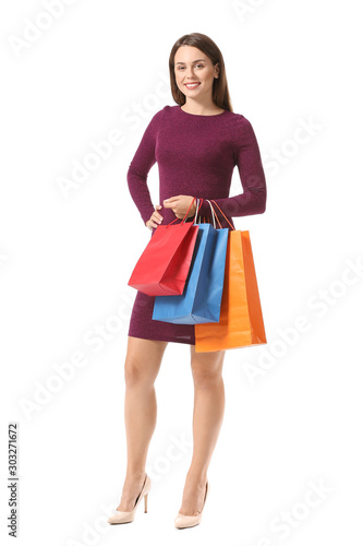 Beautiful young woman with shopping bags on white background © Pixel-Shot