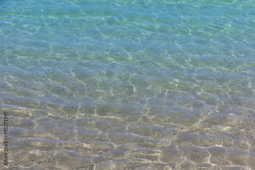 surface of blue ocean or clear water reflections on sandy beach bottom