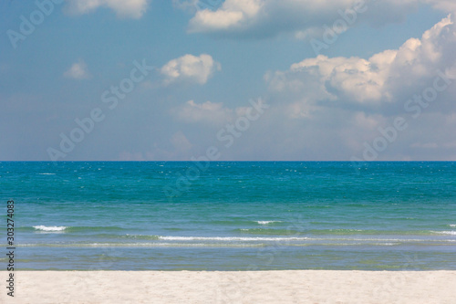 beach with clear water with clear blue calm sea and mountains on the background and beautiful sky.Summer holiday and vacation concept.