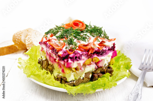 Salad with beef and vegetables on light wooden table