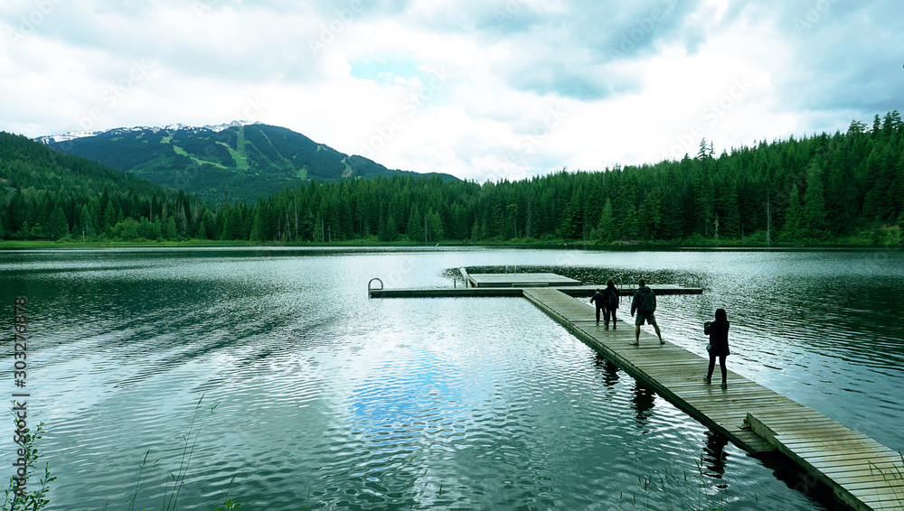 Obraz premium lake dock along overlapping mountains