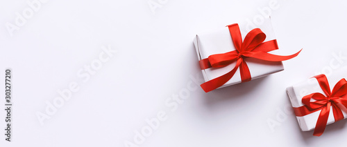 Christmas and New Year gifts wrapped in red ribbon on white