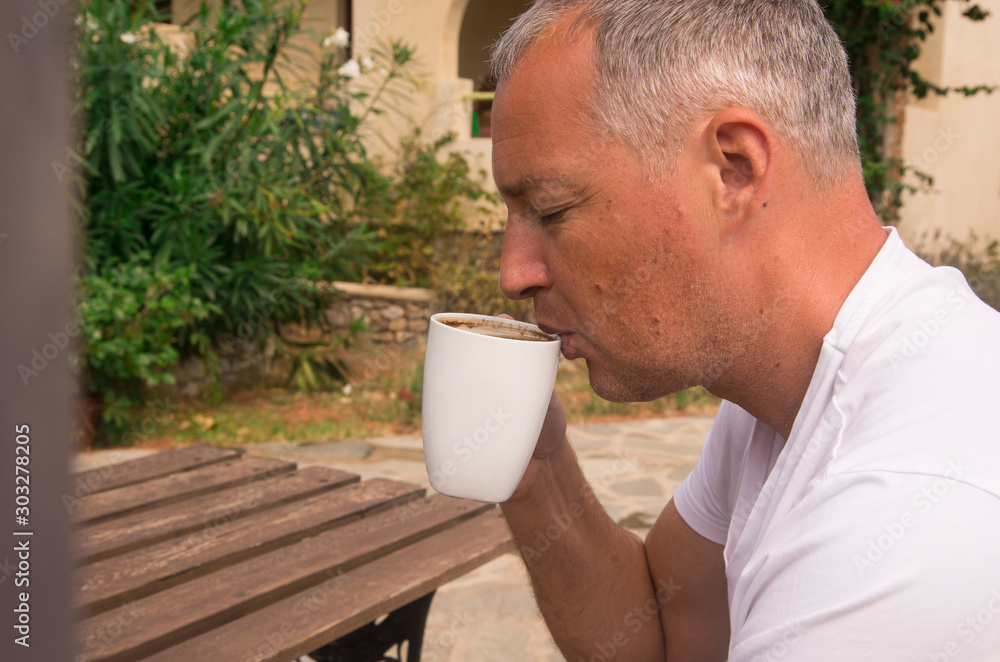 Man relaxing and having a coffee break, he holding a cup Man relaxing and having a coffee break, he holding a cup