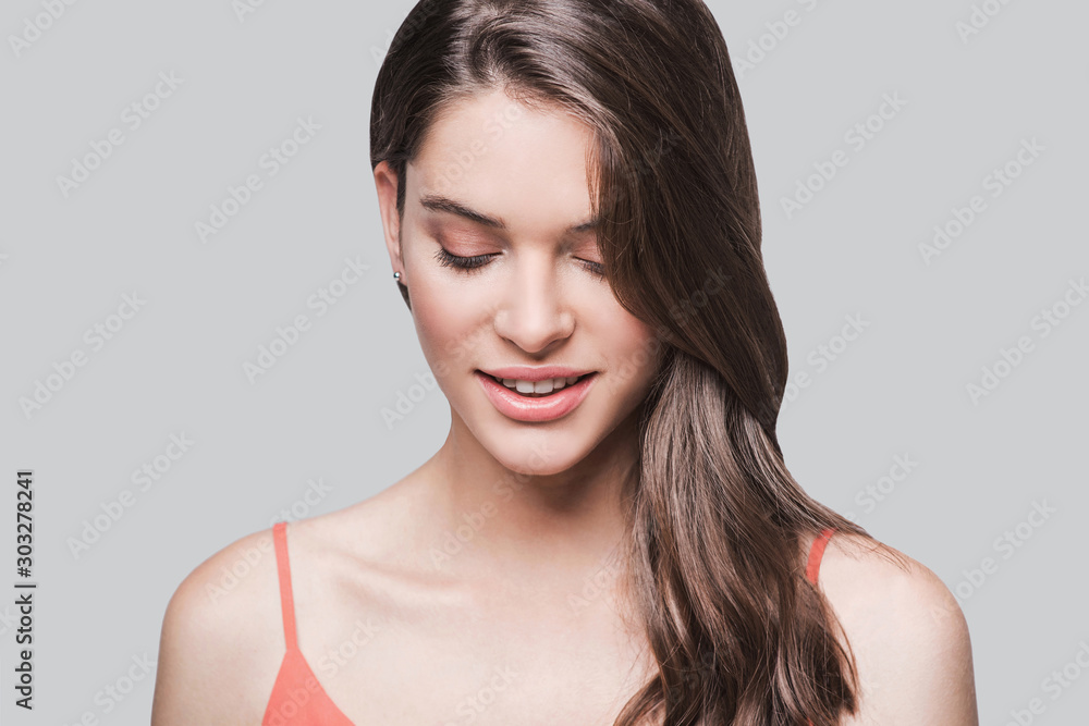 Beautiful young woman portrait. Smiling girl looking down isolated on white background Beautiful young woman portrait. Smiling girl looking down isolated on white background