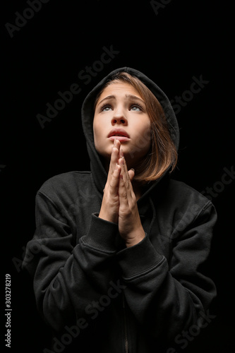 Sad teenage girl praying ag...