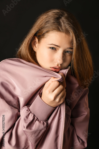 Sad teenage girl on dark ba...