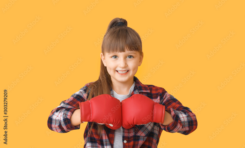 Cute little girl in boxing gloves on color background Cute little girl in boxing gloves on color background
