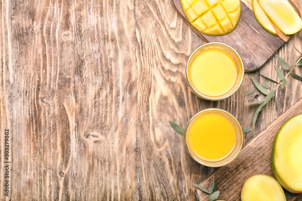 Composition with tasty mango and juice on table Composition with tasty mango and juice on table