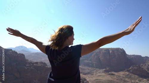 woman standing at point view in the middle of mountains raise up hands, inspirational view