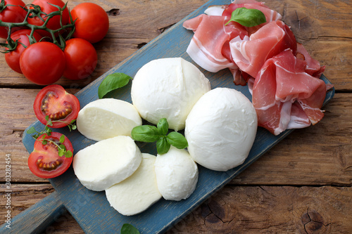 Tableau sur toile mozzarella prosciutto e pomodori delizioso piatto estivo