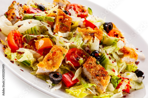 Salad with chicken meat and vegetables on white background