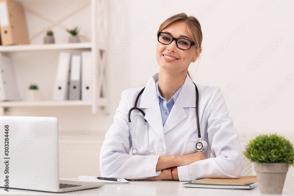 Woman Doctor Smiling Sitting At Workplace In Clinic Office Woman Doctor Smiling Sitting At Workplace In Clinic Office