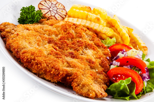 Fried pork chop, French fries and vegetables
