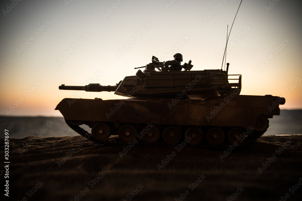 Fototapeta premium War Concept. Armored vehicle silhouette fighting scene on war fog sky background. American tank at sunset.