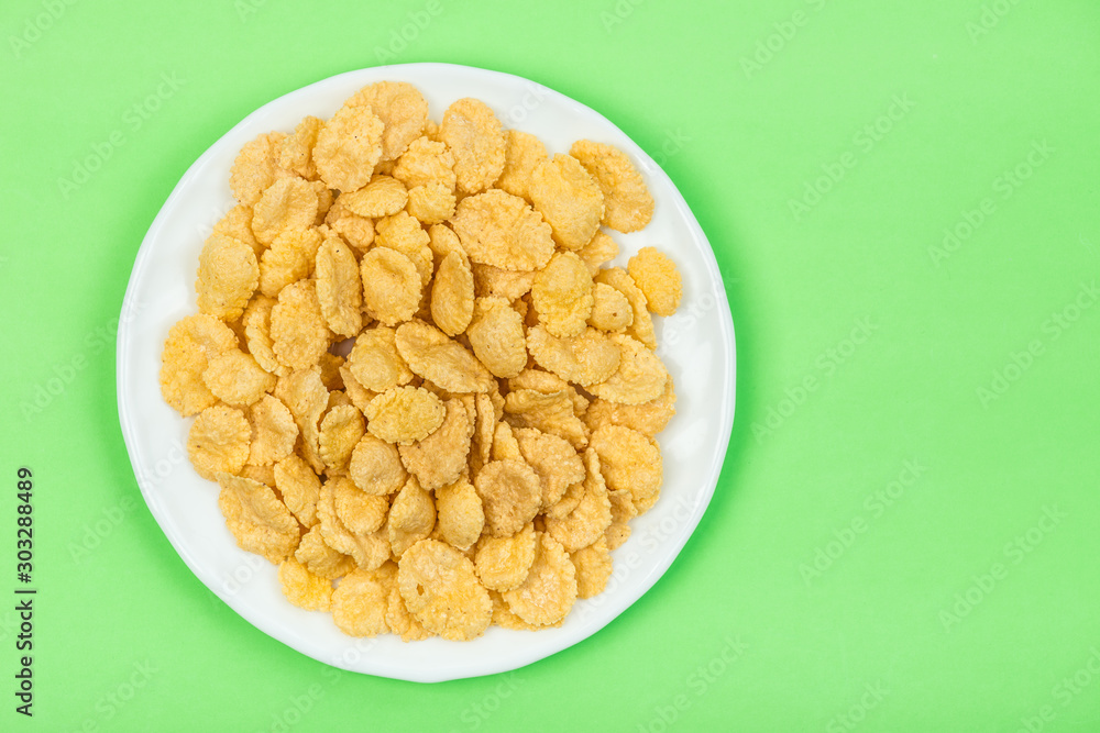 Cornflakes isolated close up on green Cornflakes isolated close up on green