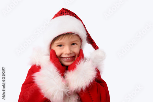 Smiling face of a child dressed as Santa. Isolated on white, close up.