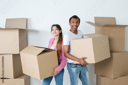 Happy young couple with boxes boxes In new home.