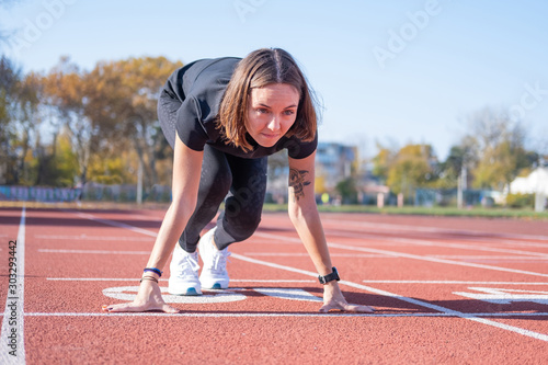 Young female runner training in summer day outdoors on the studium
