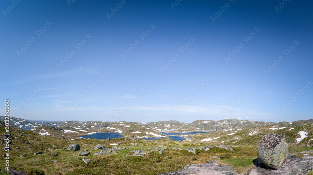 Huge blouder in mountain landscape with melting snow and lakes panorama Norway
