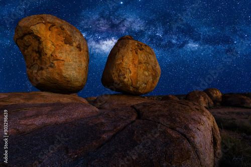 Scenic nocturnal australian outback landscape of Devils Marbles The Eggs by night with milky way, stars field and galaxies. Granite boulders of Karlu Karlu in Northern Territory, Central Australia.