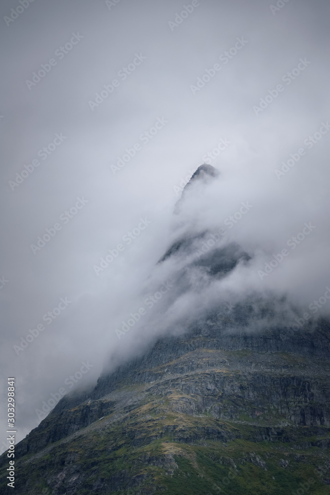 Tower of Innerdalen mountain peak up close shrouded in fog mysterious scene