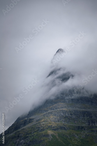 Tower of Innerdalen mountain peak up close shrouded in fog mysterious scene