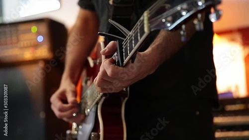 young man playing a beautiful red guitar