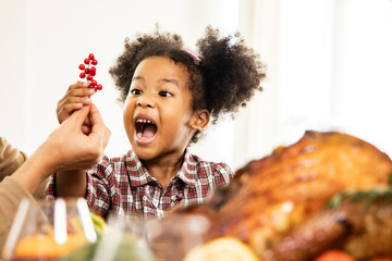 Thanksgiving Celebration Tradition Family Dinner Concept.family having holiday dinner and cutting turkey.Young black adult woman and her daughter happy.