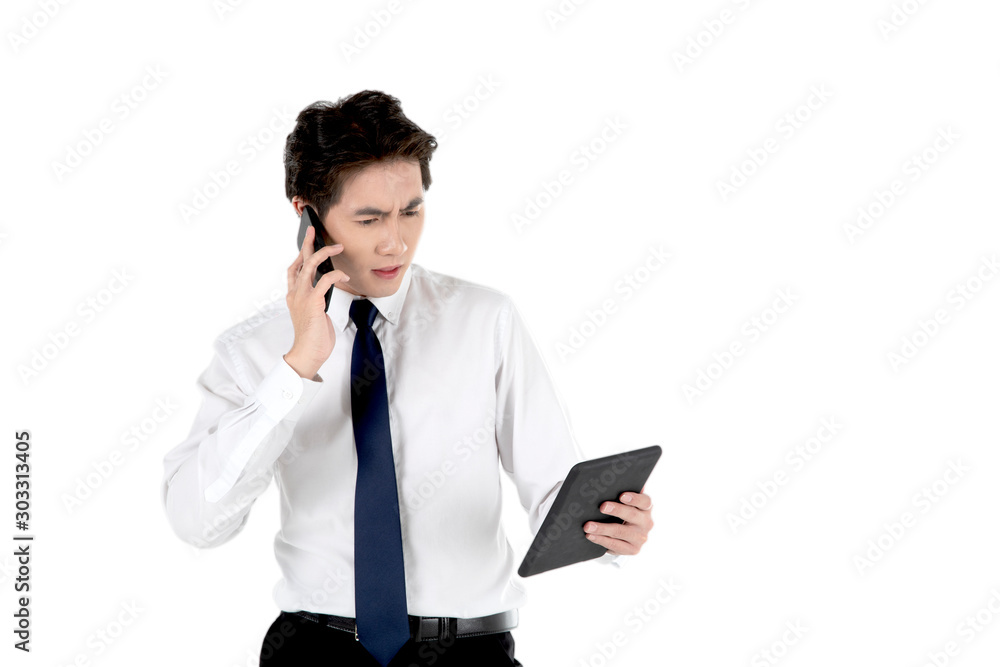 Asian man holds mobile phone, gets curious and thinks about something while looking at a tablet, isolated on white background. For business, finance, education, industrial and technology concept. Asian man holds mobile phone, gets curious and thinks about something while looking at a tablet, isolated on white background. For business, finance, education, industrial and technology concept.