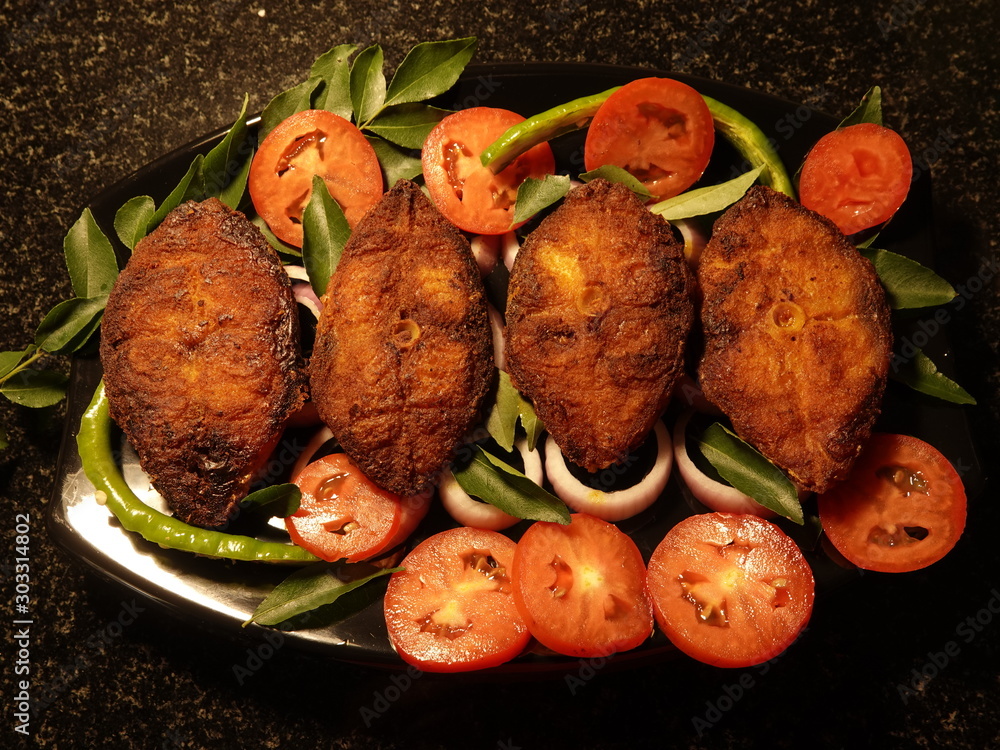 Roasted King fish fry with onion, tomato decorated on the top of the