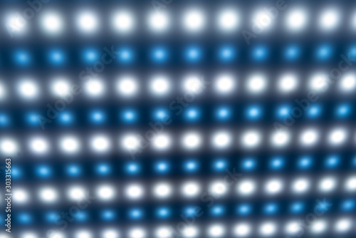 Close-up of a large panel with bright cold blurry lights, luminous buttons in the manufacture of radio products or in a disco. Equalizer and factory equipment concept