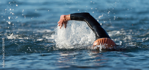 Man swimmer swimming crawl in blue sea training for triathlon